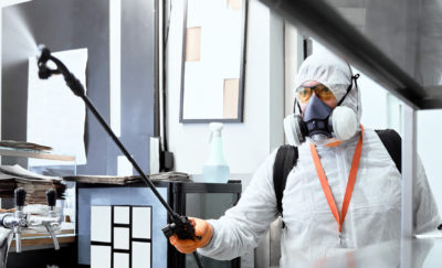 Exterminator spraying pesticides in office - Pest control services with City Termite & Pest Control in Malvern, AR